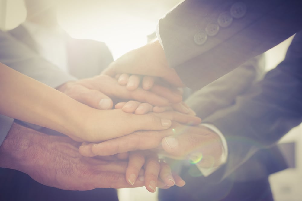 Business team standing hands together in the office-1